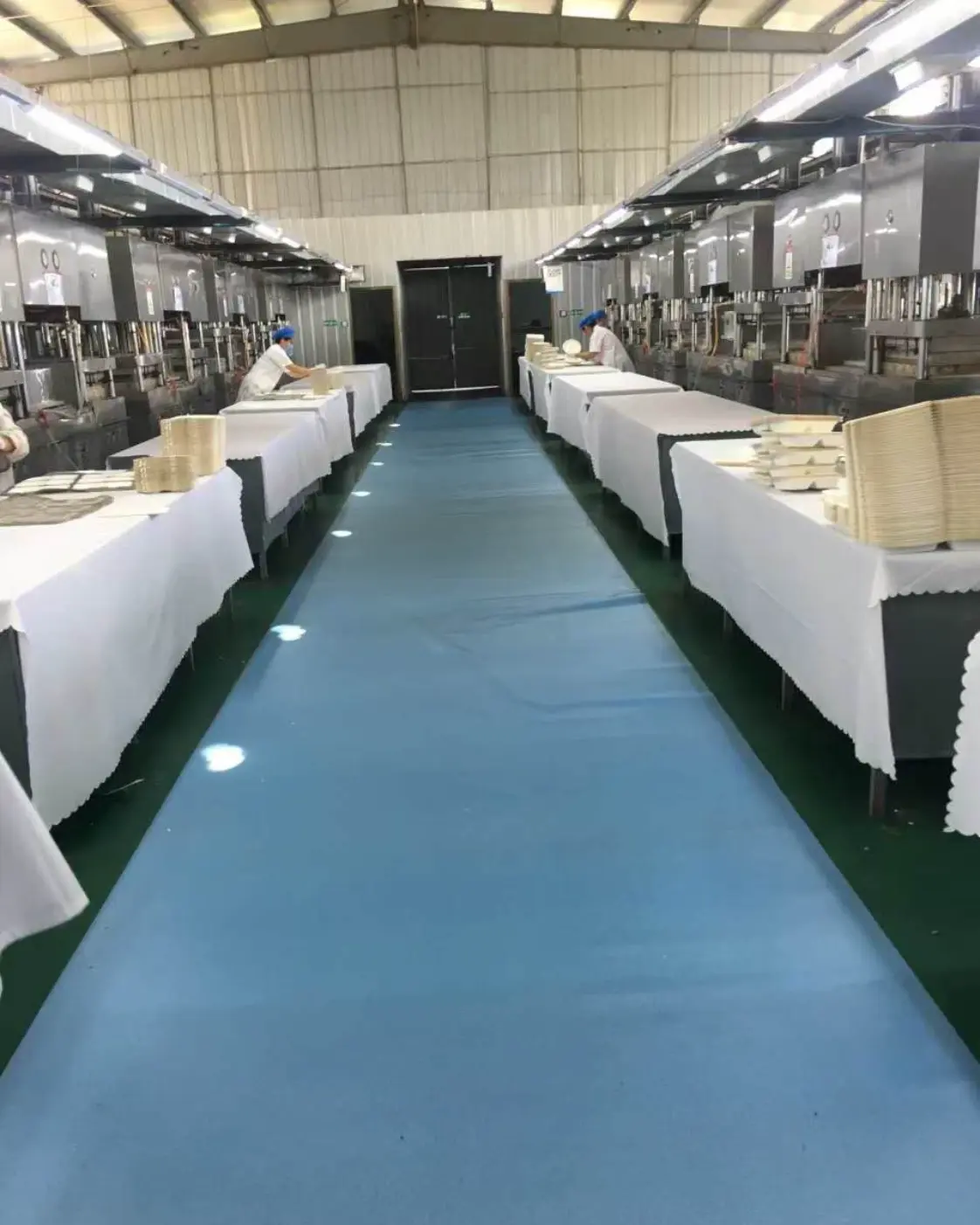 Rows of bagasse tableware hot press equipment inside the production workshop